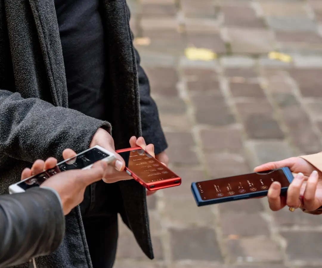 Tri prijatelja sretno drže svoje prevoditelje, upuštaju se u razgovor i dijele zajedničke trenutke. 